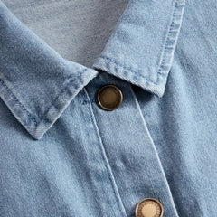 Light blue denim flared long sleeve wide-leg jumpsuit for women by Christine Brewer, showing the stylish design and fit.