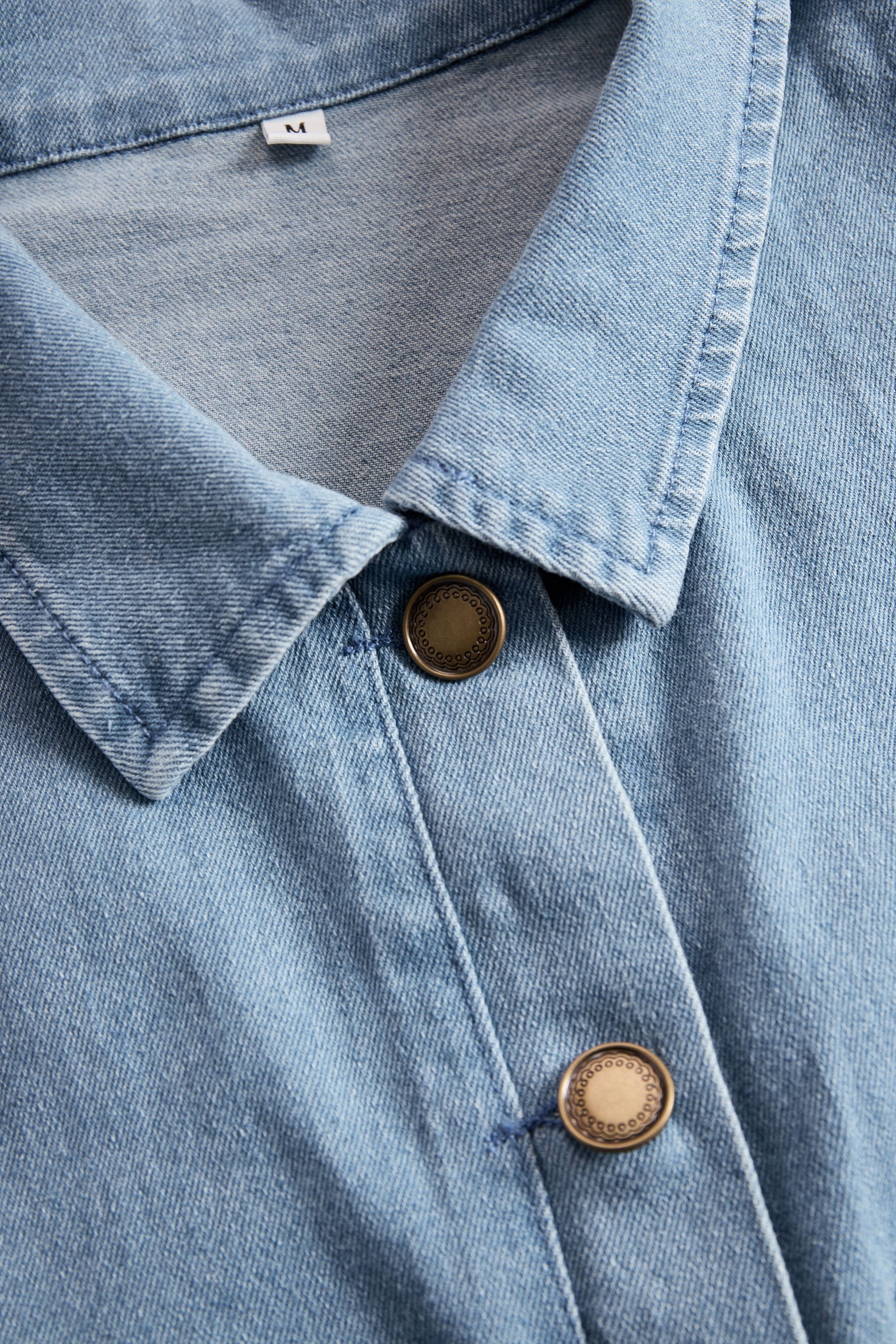 Light blue denim flared long sleeve wide-leg jumpsuit for women by Christine Brewer, showing the stylish design and fit.