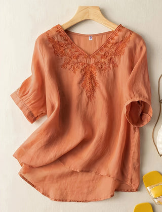 Light beige V-neck linen summer blouse for women with a flowy, casual fit, by Christine Brewer, showing front view.