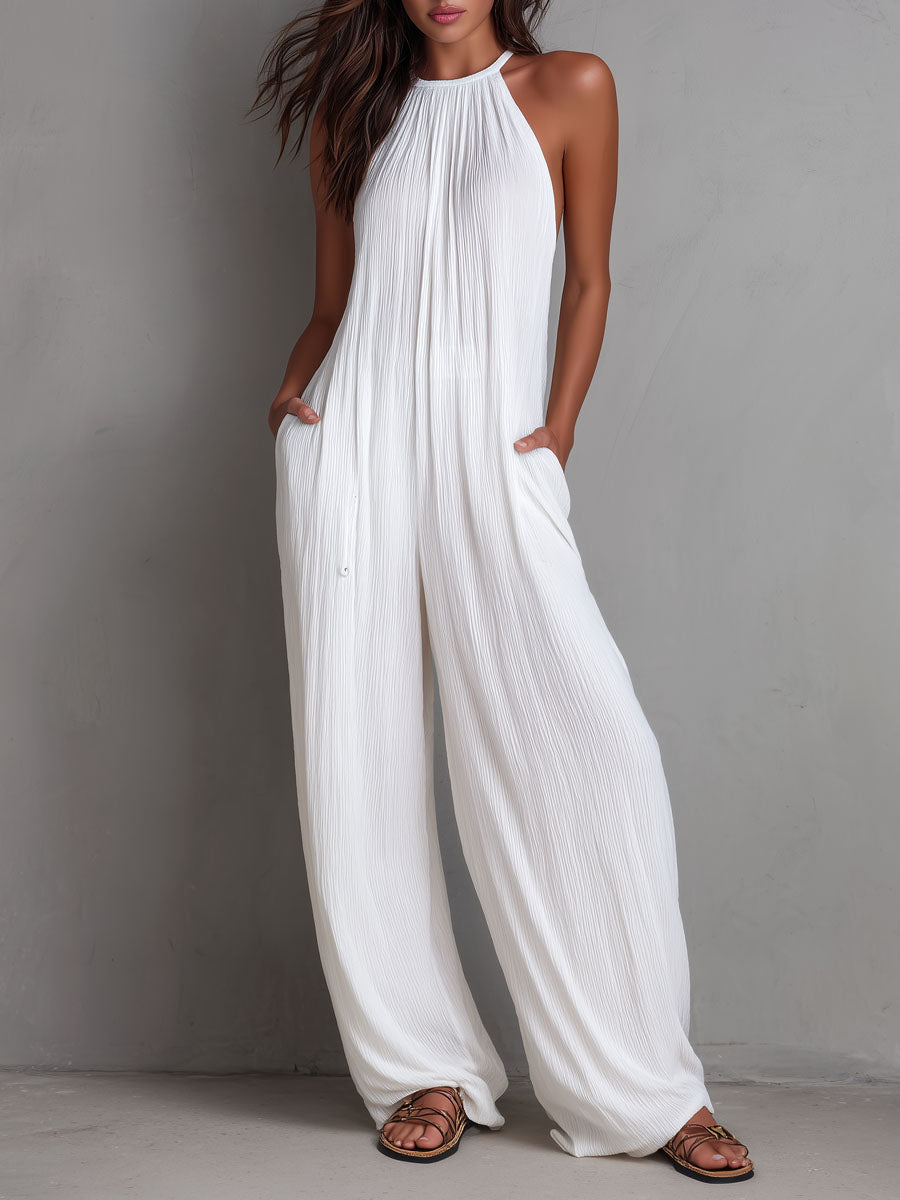 White pleated halter neck wide-leg resort jumpsuit for women by Christine Brewer, featuring stylish pleats and a halter neckline.