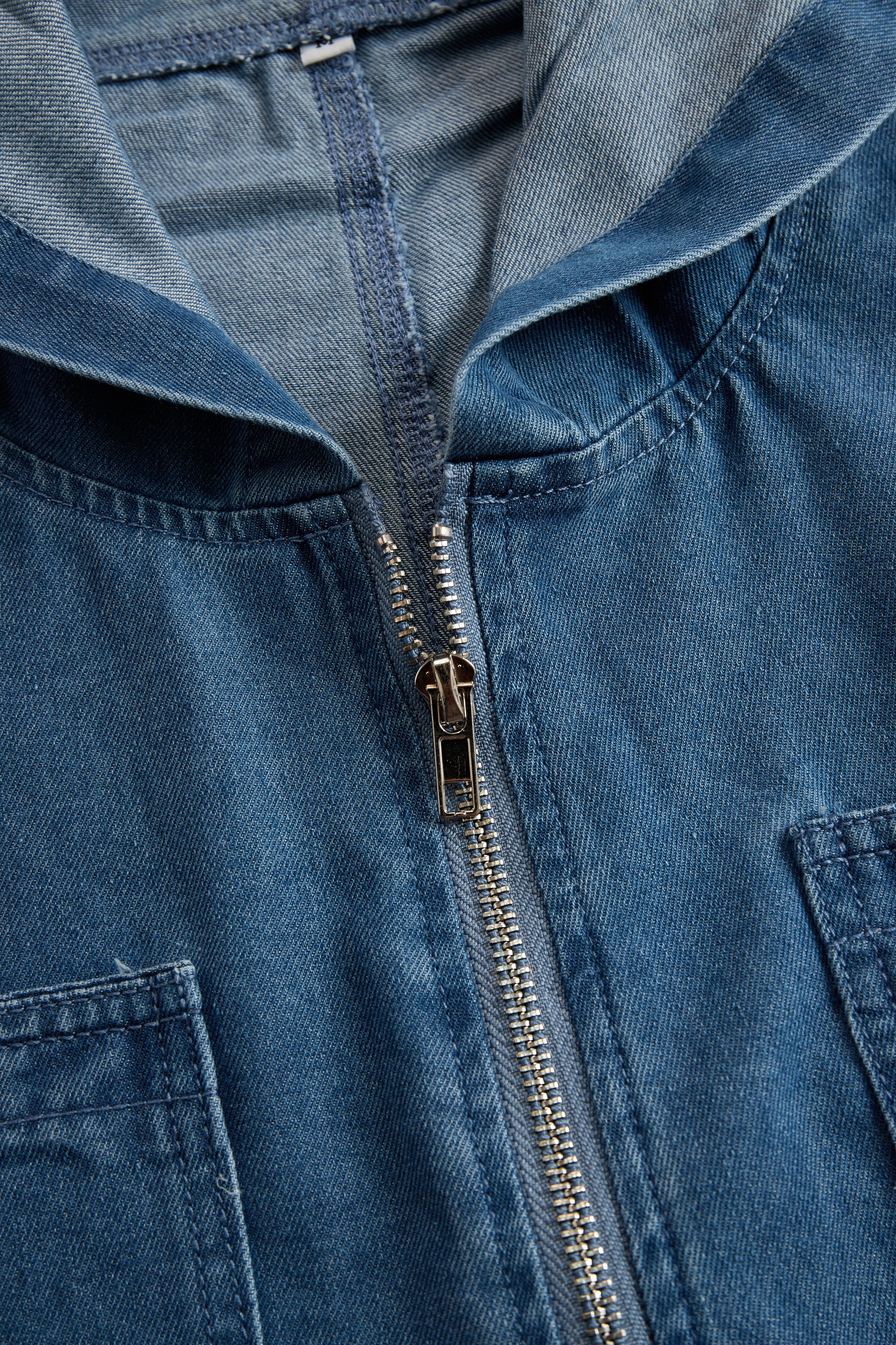 Women’s casual loose retro denim jumpsuit with long sleeves, hood, zipper, and pockets by Christine Brewer, styled as pants.