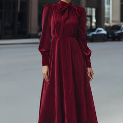 Burgundy velvet pleated bow-neck midi dress by Christine Brewer, featuring a sophisticated cocktail dress design with elegant pleats.