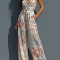 White floral satin halter neck jumpsuit for women with wrap front and wide-leg pants by Christine Brewer.