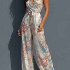 White floral satin halter neck jumpsuit with wide-leg pants, featuring a wrap front design, by Christine Brewer.