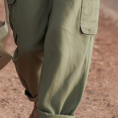 Green multi-pocket cargo trousers for women by Christine Brewer, featuring multiple functional pockets and a relaxed fit.
