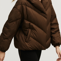 Brown cropped hooded puffer jacket for women by Christine Brewer, showcasing the lightweight, quilted design and hood detail.