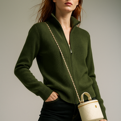 Woman wearing a green wool zip-up cardigan by Christine Brewer, featuring a stylish jean-inspired design and front zipper.