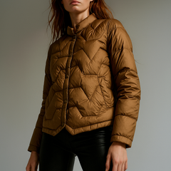 Brown quilted puffer jacket for women by Christine Brewer, featuring short design and quilted texture.