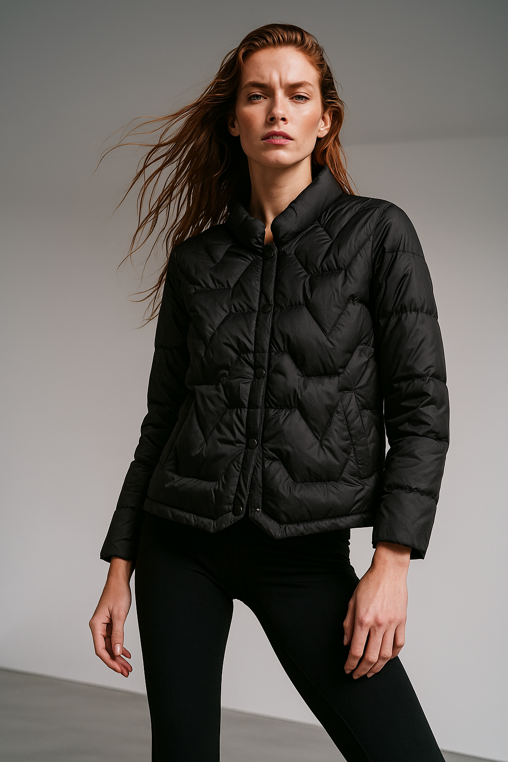 Black Aurora short quilted puffer jacket for women by Christine Brewer, featuring a stylish, insulated design with a high collar and zip closure.