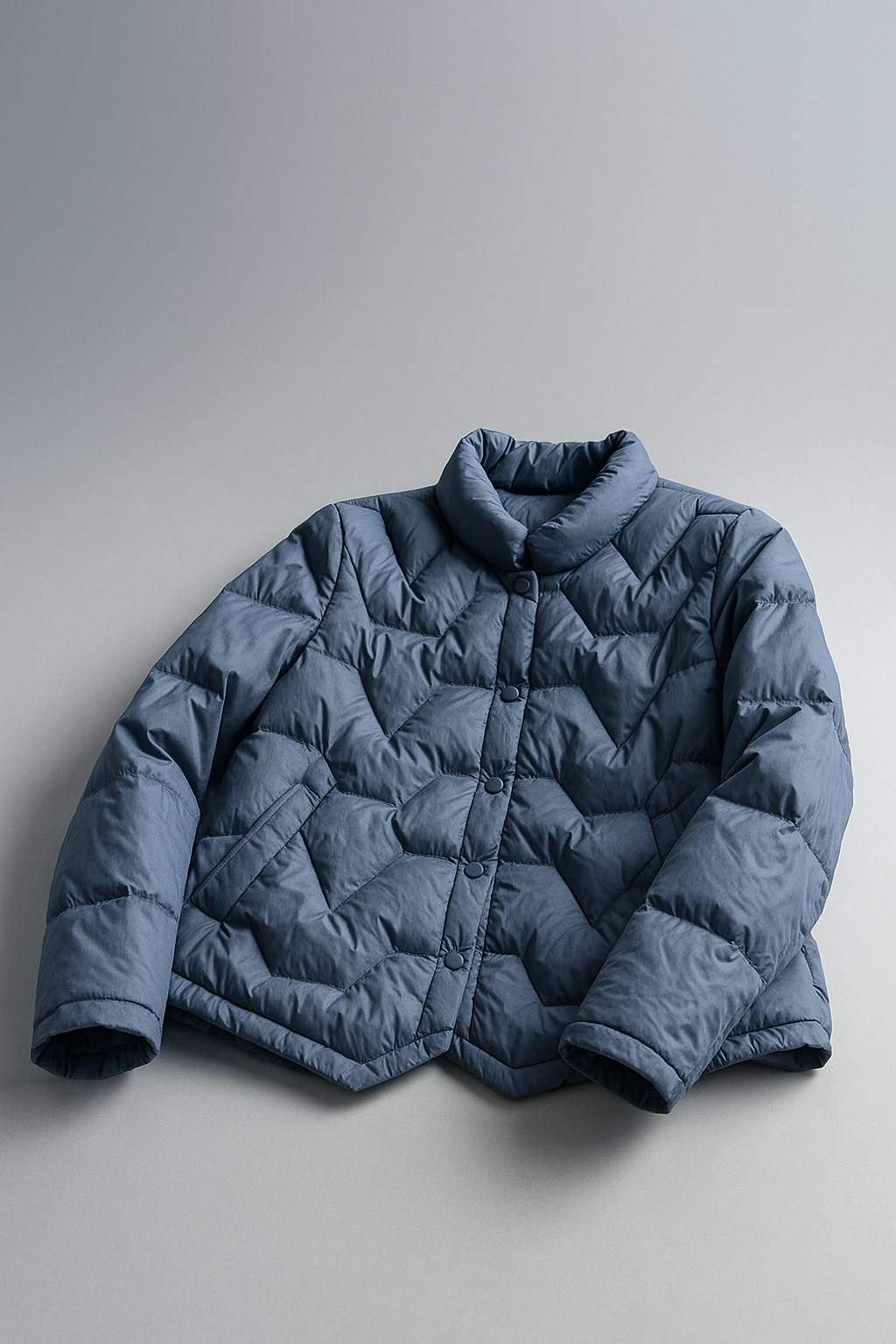 Elegant quilted puffer jacket for women by Christine Brewer, featuring a short, stylish design with a shiny, padded exterior.