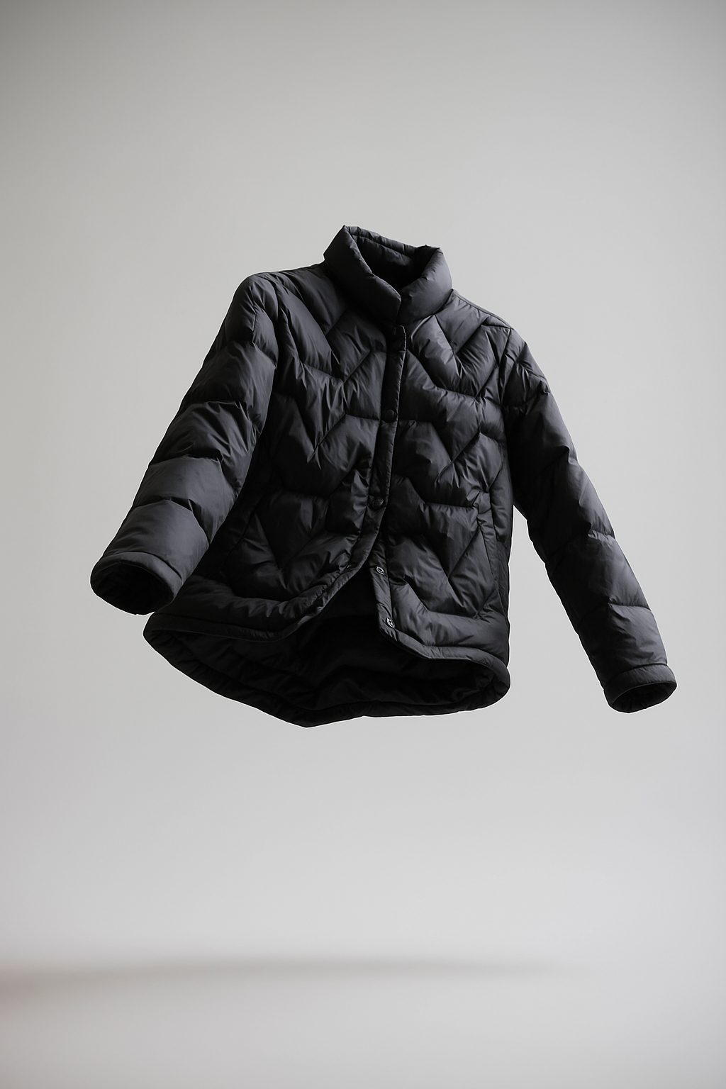 Black Aurora short quilted puffer jacket for women by Christine Brewer, shown with a sleek, padded design and standing collar.