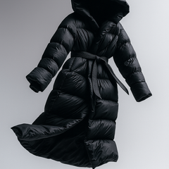 Black long belted puffer jacket for women by Christine Brewer, featuring a floating design and stylish, insulated exterior.