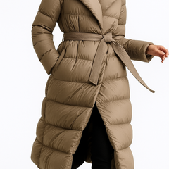 Long belted puffer jacket for women by Christine Brewer, featuring a stylish, quilted design and a waist belt for a chic look.