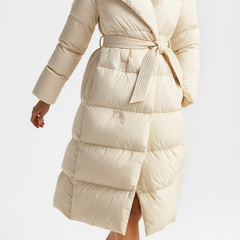 Elegant long belted puffer jacket for women by Christine Brewer, featuring a stylish quilted design and cozy insulation.