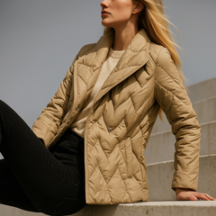 Beige belted quilted puffer jacket for women by Christine Brewer, featuring a stylish quilted design and a waist belt.