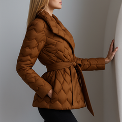 Brown quilted puffer jacket for women by Christine Brewer with belted design and warm quilted insulation.