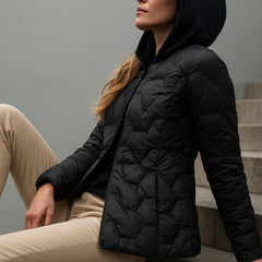 Black Zoe quilted puffer jacket for women by Christine Brewer, hooded winter outerwear with quilted design and comfortable fit.