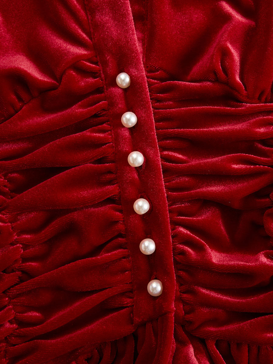Red velvet pleated ruffled long sleeve blouse by Christine Brewer, featuring elegant ruffles and pleats on a rich red fabric.