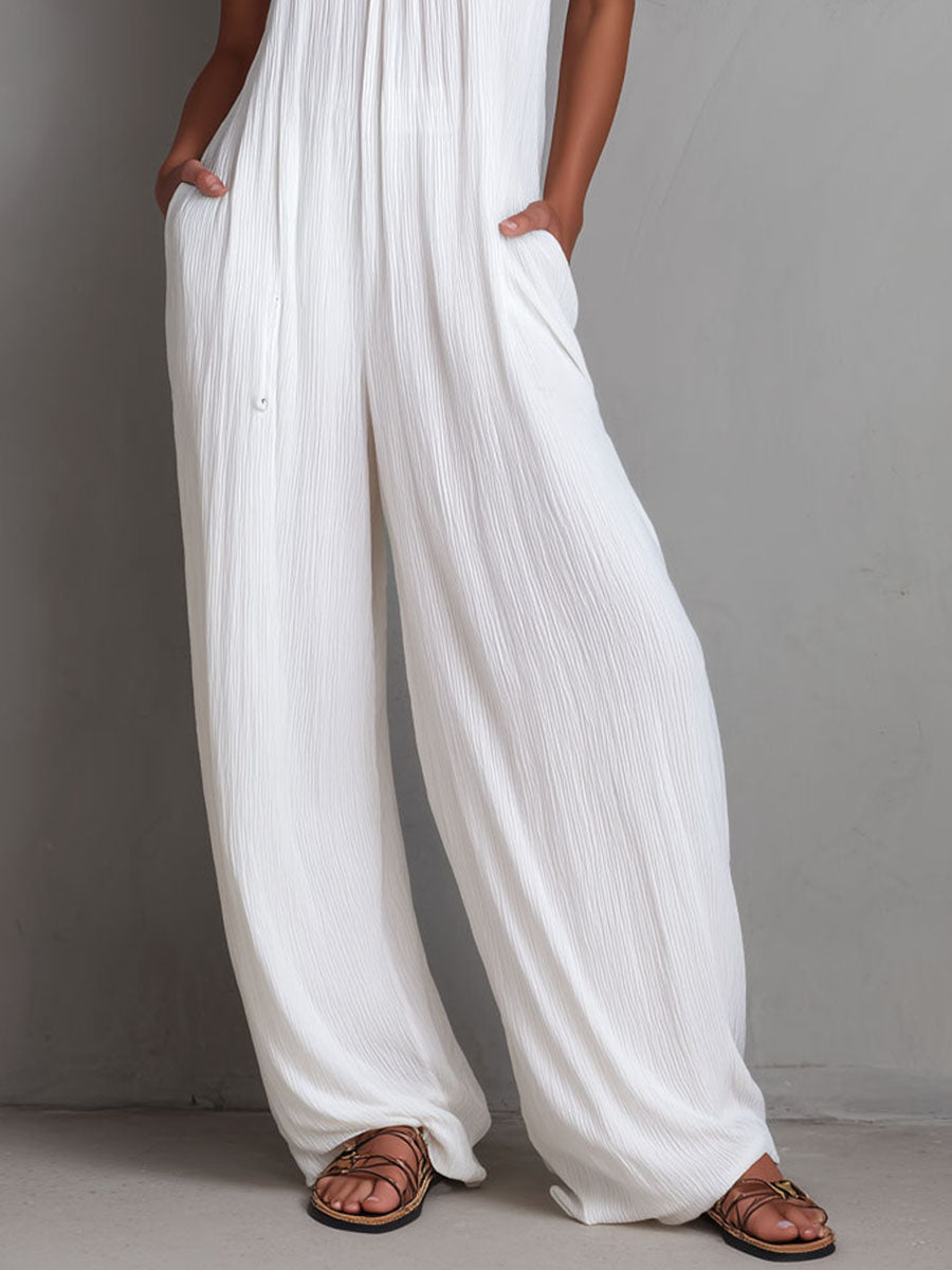 White pleated halter neck wide-leg resort jumpsuit for women, featuring stylish pants from Christine Brewer.