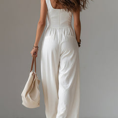 White sleeveless wide-leg jumpsuit with patch pockets for women, by Christine Brewer, shown in a stylish, casual outfit.
