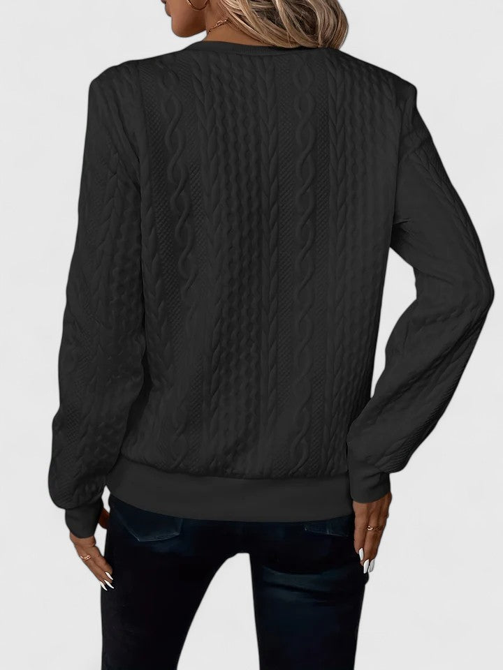 Pink knit sweater for women by Christine Brewer, featuring a cozy, textured design, worn casually in a relaxed setting.
