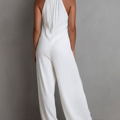 White pleated halter neck wide-leg resort jumpsuit for women by Christine Brewer, shown with flowing fabric and stylish design.