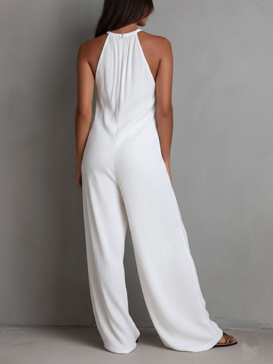 White pleated halter neck wide-leg resort jumpsuit for women by Christine Brewer, shown with flowing fabric and stylish design.