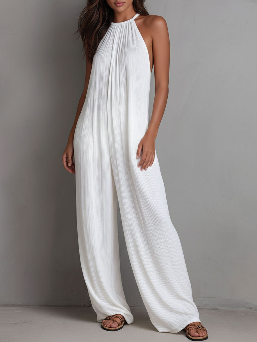 White pleated halter neck wide-leg resort jumpsuit for women by Christine Brewer, shown with flowing fabric and stylish design.