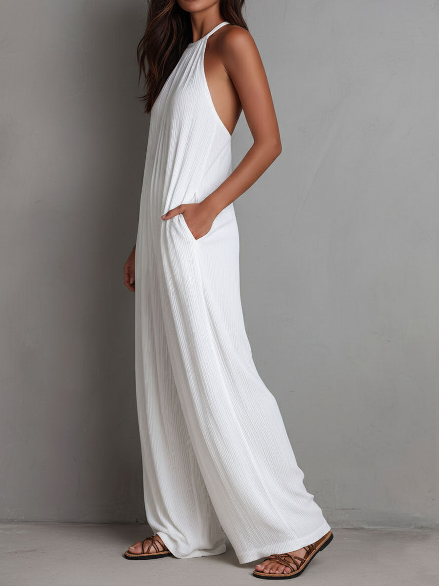 White pleated halter neck wide-leg resort jumpsuit for women by Christine Brewer, featuring flowing fabric and stylish design.