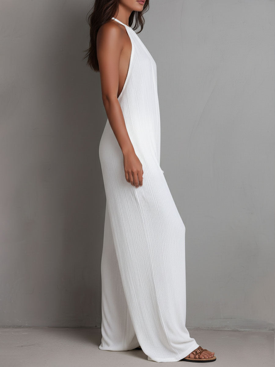 White pleated halter neck wide-leg resort jumpsuit for women by Christine Brewer, featuring flowing fabric and stylish design.