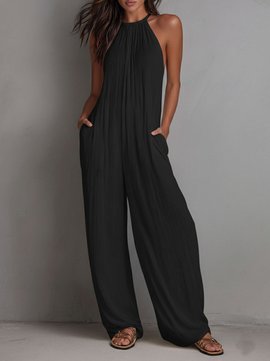 White pleated halter neck wide-leg resort jumpsuit for women, featuring stylish wide-leg pants from Christine Brewer.