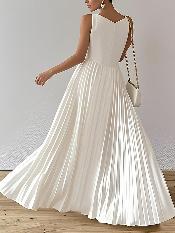 White A-line maxi dress by Christine Brewer featuring loose fit, pleats, and a V-neck, perfect for elegant casual wear.