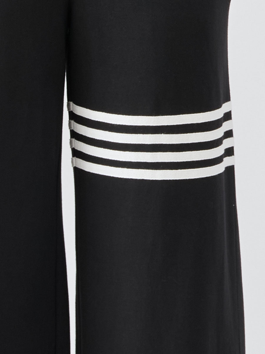 Black striped sleeveless hooded jumpsuit for women, stylish pants by Christine Brewer, shown on a model in a casual setting.