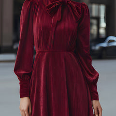 Burgundy velvet pleated midi dress with bow-neck detail by Christine Brewer, perfect for cocktail occasions.