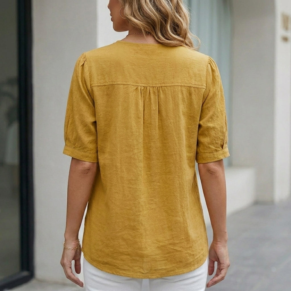 Back view of Christine Brewer summer women's linen blouse with short sleeves and front pockets.