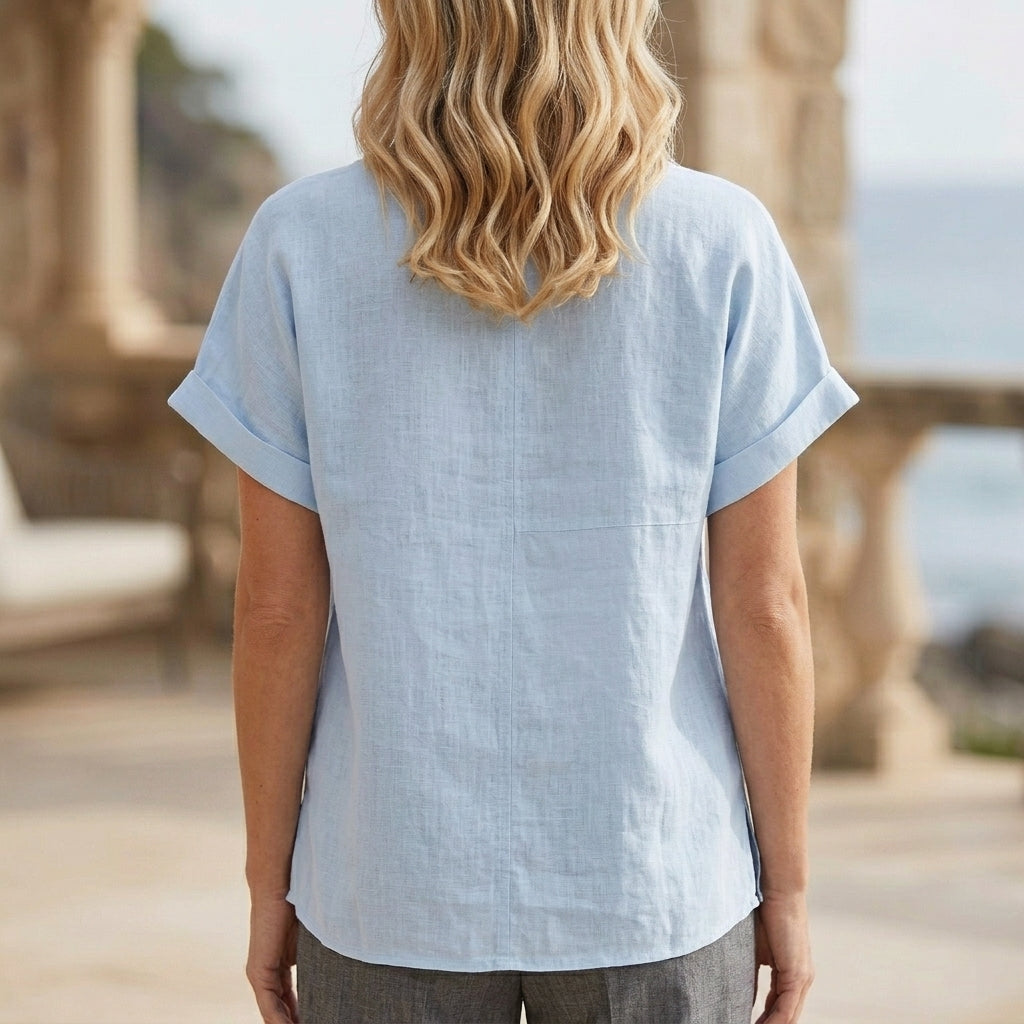Back view of a women's summer denim blouse with V-neck and short sleeves by Christine Brewer, casual and stylish for warm weather.