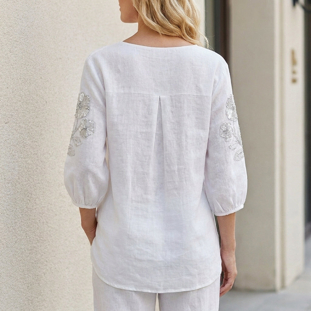 Back view of Christine Brewer summer floral blouse for women with puff sleeves, stylish lightweight top for warm weather.