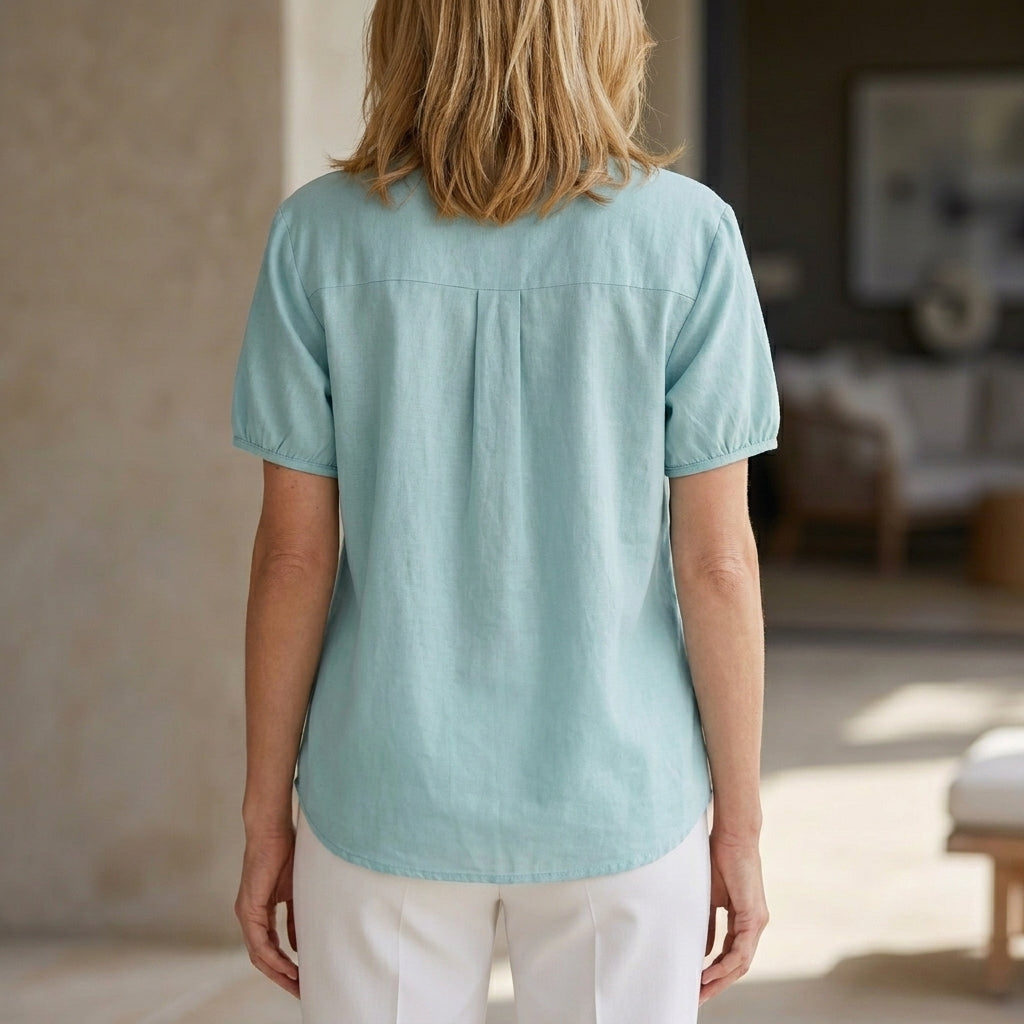 Back view of Christine Brewer women's summer blouse with puff sleeves, denim fabric, button front, lightweight top for warm weather.
