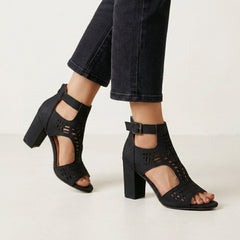Black women's cut-out block-heel sandals with ankle buckle by Christine Brewer, showcasing stylish design and comfortable fit.