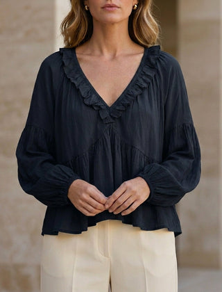 Black women's summer blouse with v-neck, long sleeves, and ruffle details from Christine Brewer, made of denim fabric.
