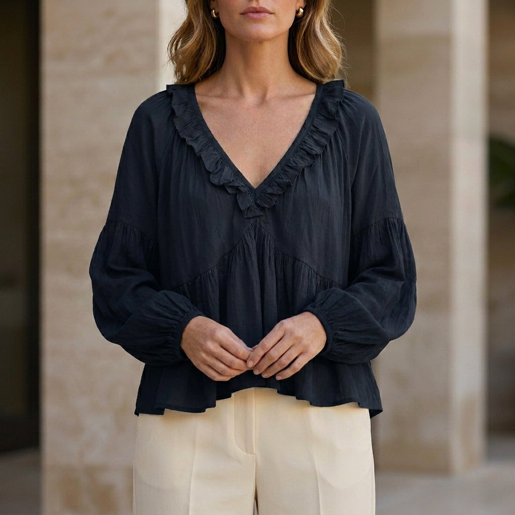 Black women's summer blouse with v-neck, long sleeves, and ruffle details from Christine Brewer, made of denim fabric.