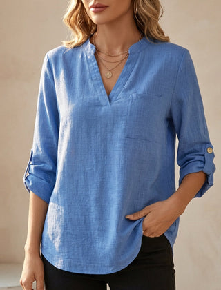 Blue women's summer blouse by Christine Brewer featuring a V-neck and flowy linen fabric, perfect for warm weather.