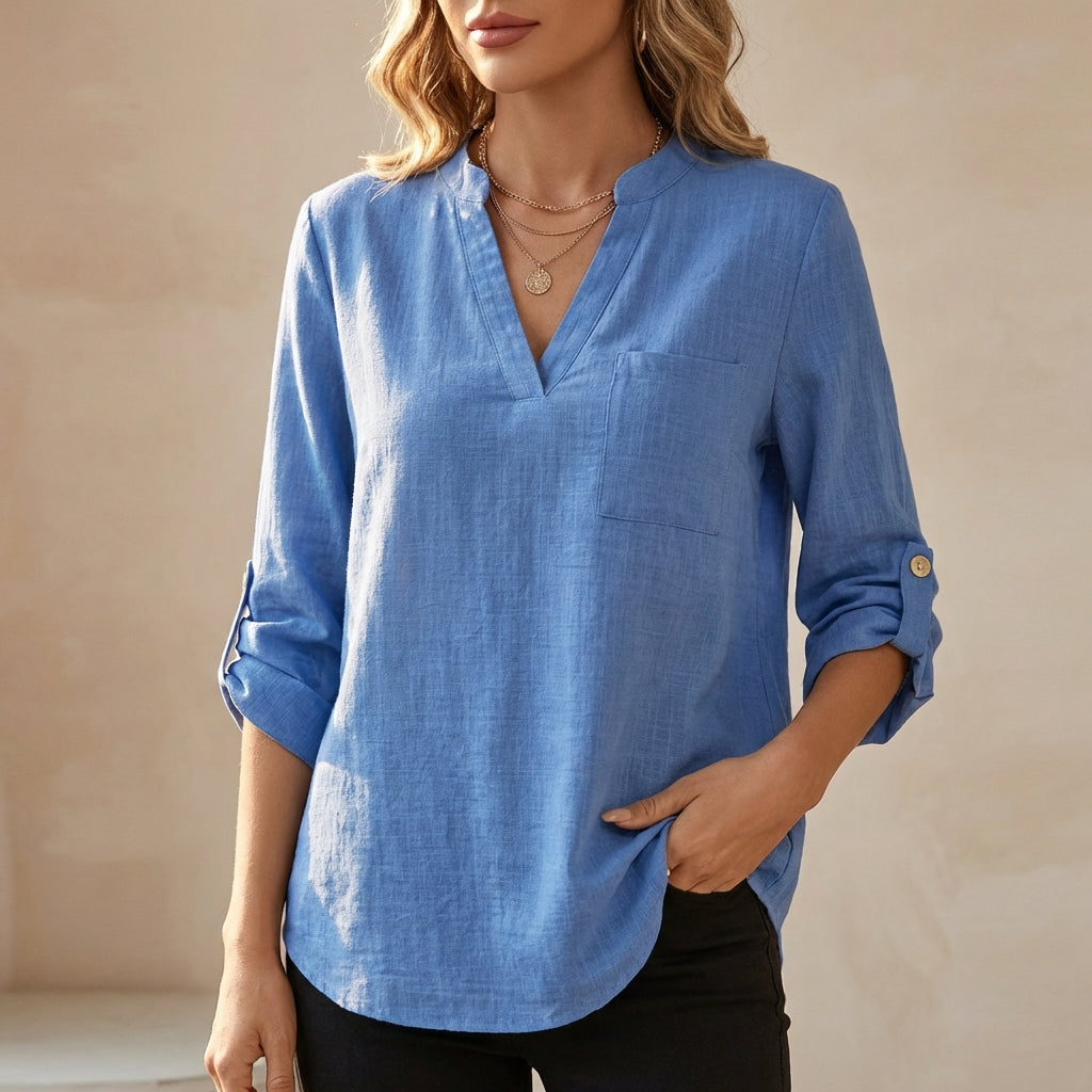 Blue women's summer blouse by Christine Brewer featuring a V-neck and flowy linen fabric, perfect for warm weather.