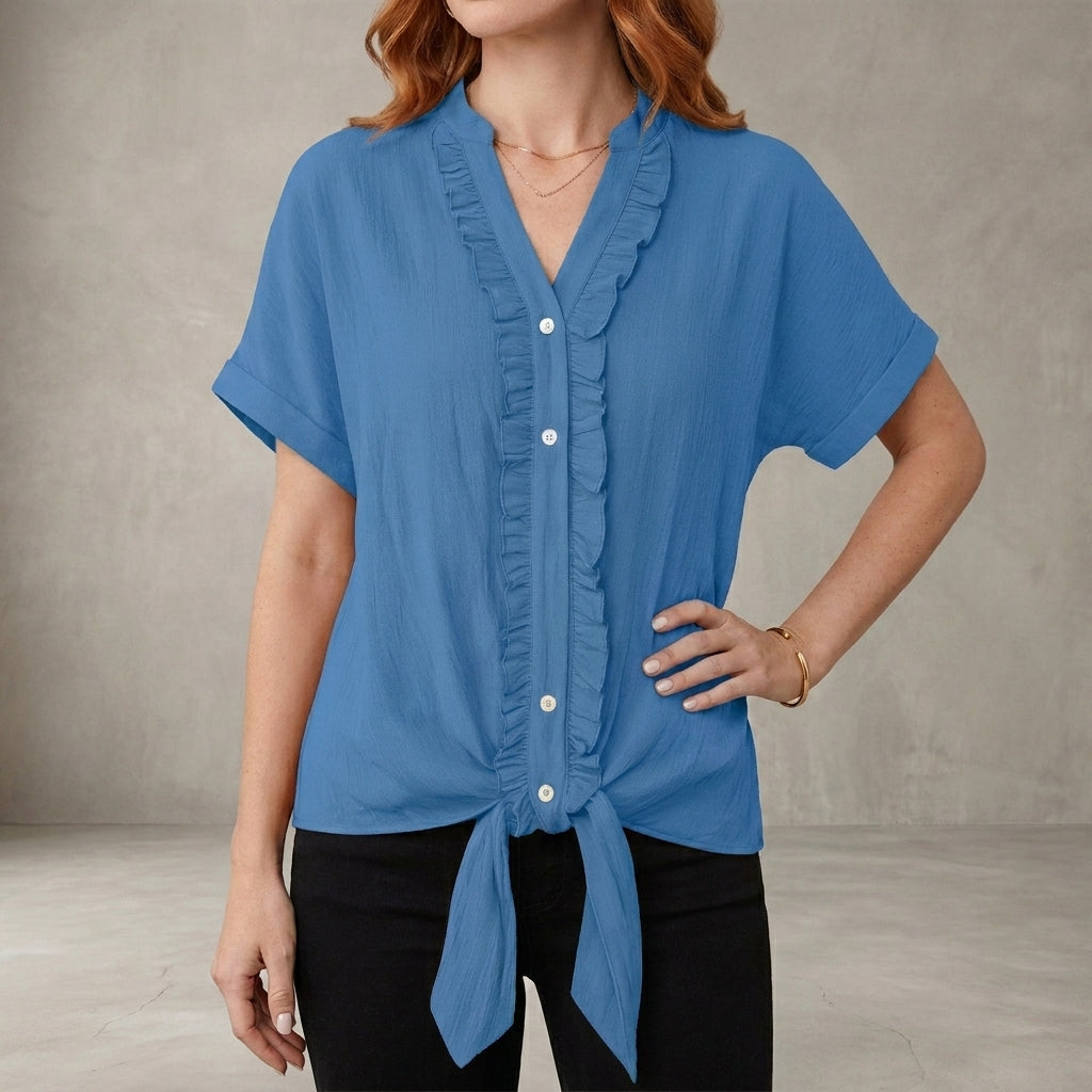 Blue V-neck denim summer blouse for women with ruffle details, casual style by Christine Brewer, shown on model.