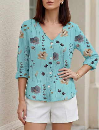 Blue floral V-neck summer blouse for women by Christine Brewer, featuring denim fabric and button-front design.