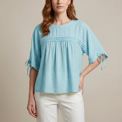 Blue linen summer blouse for women by Christine Brewer, flowy and lightweight, shown on a model with short sleeves and relaxed fit.