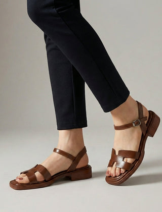 Brown ankle-length flat sandals with ankle strap and buckle by Christine Brewer, featuring a stylish and comfortable design.