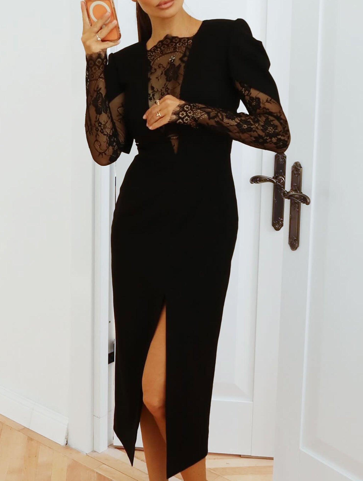 Black openwork dress with lace slit and cinched waist by Christine Brewer, featuring intricate lace details and a fitted silhouette.