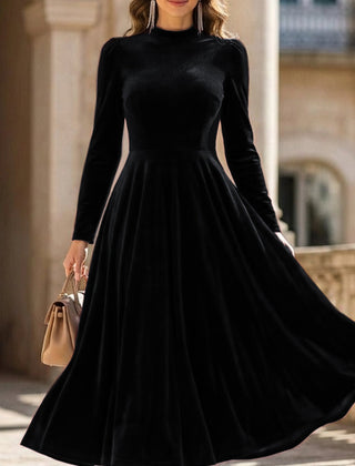 Black velvet round neck long-sleeved dress by Christine Brewer, shown on a hanger with a smooth fabric finish.
