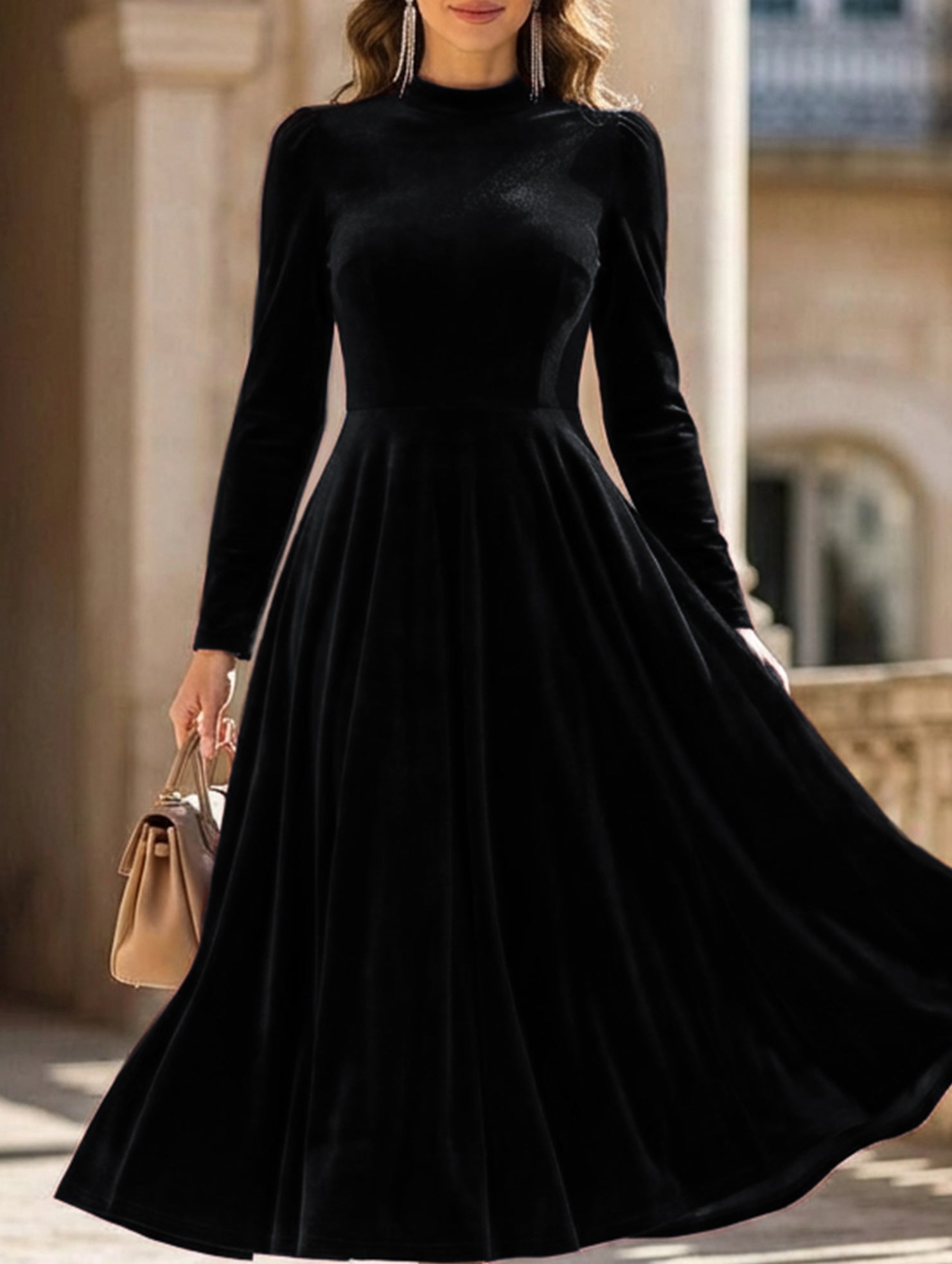 Black velvet round neck long-sleeved dress by Christine Brewer, shown on a hanger with a smooth fabric finish.